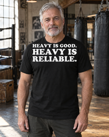 AI-generated lifestyle visualization of a person wearing the Heavy Is Good. Heavy Is Reliable. black tri-blend quote T-shirt in a working boxing gym