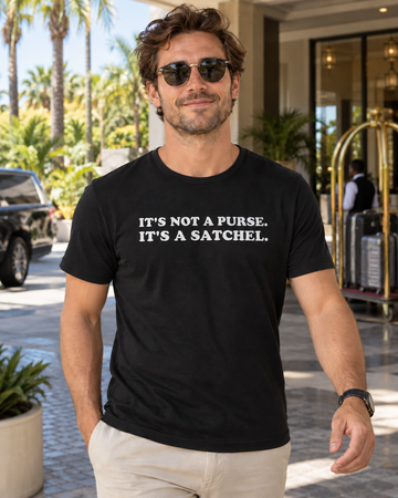 AI-generated lifestyle visualization of a man wearing the black tri-blend Its Not a Purse Its a Satchel quote T-shirt at a sunny hotel entrance