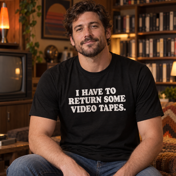 AI-generated lifestyle visualization of a person wearing the black tri-blend I Have to Return Some Video Tapes quote T-shirt