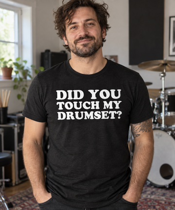 AI-generated lifestyle visualization of an adult wearing a black tri-blend tee with white DID YOU / TOUCH MY / DRUMSET? lettering