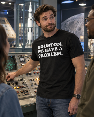 AI-generated lifestyle visualization: person wearing the black tri-blend Houston, We Have a Problem. quote T-shirt in a retro science museum control-room exhibit with practical consoles and cool overhead light