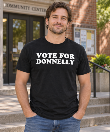 AI-generated lifestyle visualization: person wearing the black tri-blend Vote for Donnelly quote T-shirt outside a neighborhood community center