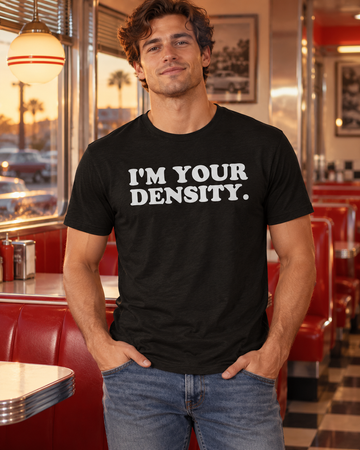 AI-generated lifestyle visualization: person wearing the black tri-blend I'm Your Density. quote T-shirt in a 1950s-inspired diner booth with chrome trim, red vinyl, and warm evening light