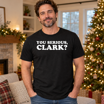 AI-generated holiday living-room lifestyle visualization of a man wearing the black tri-blend You Serious Clark quote T-shirt