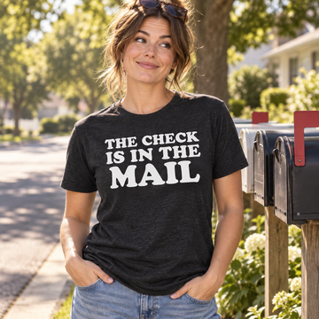 AI-generated lifestyle visualization: person wearing the black tri-blend The Check Is in the Mail quote T-shirt beside neighborhood mailboxes
