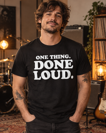 AI-generated lifestyle visualization: person wearing the black tri-blend One Thing. Done Loud. Quote Club T-shirt in a rehearsal studio