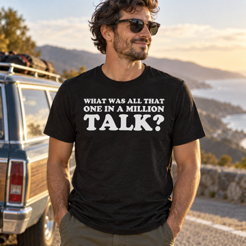 AI-generated lifestyle visualization: person wearing the black tri-blend What Was All That One in a Million Talk? quote T-shirt at a roadside overlook