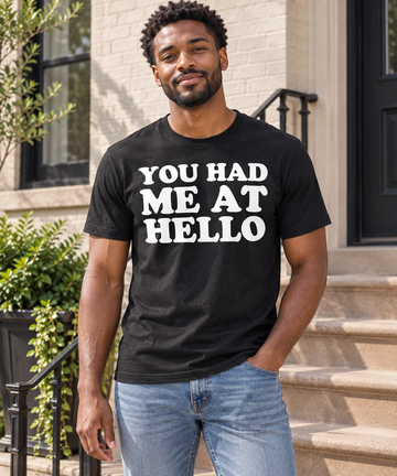 AI-generated lifestyle visualization: person wearing the black tri-blend You Had Me at Hello quote T-shirt on a city stoop