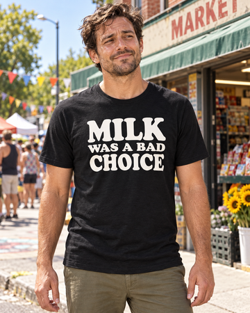 AI-generated lifestyle visualization: person wearing the black tri-blend Milk Was a Bad Choice quote T-shirt outside a neighborhood market