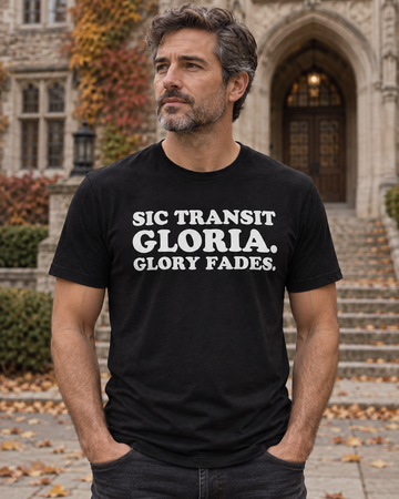 AI-generated lifestyle visualization: person wearing the black tri-blend Sic Transit Gloria. Glory Fades. quote T-shirt in a formal stone school courtyard in early autumn with centered steps and soft overcast light