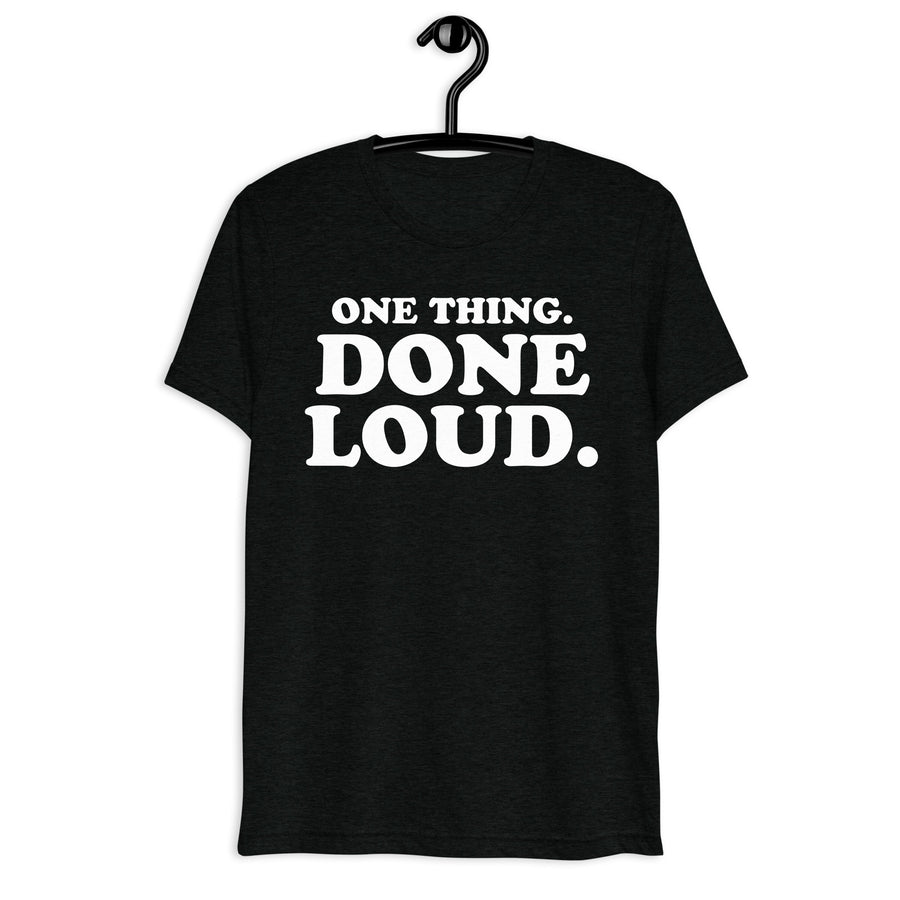 Front hanger mockup of the black tri-blend One Thing. Done Loud. Quote Club T-shirt