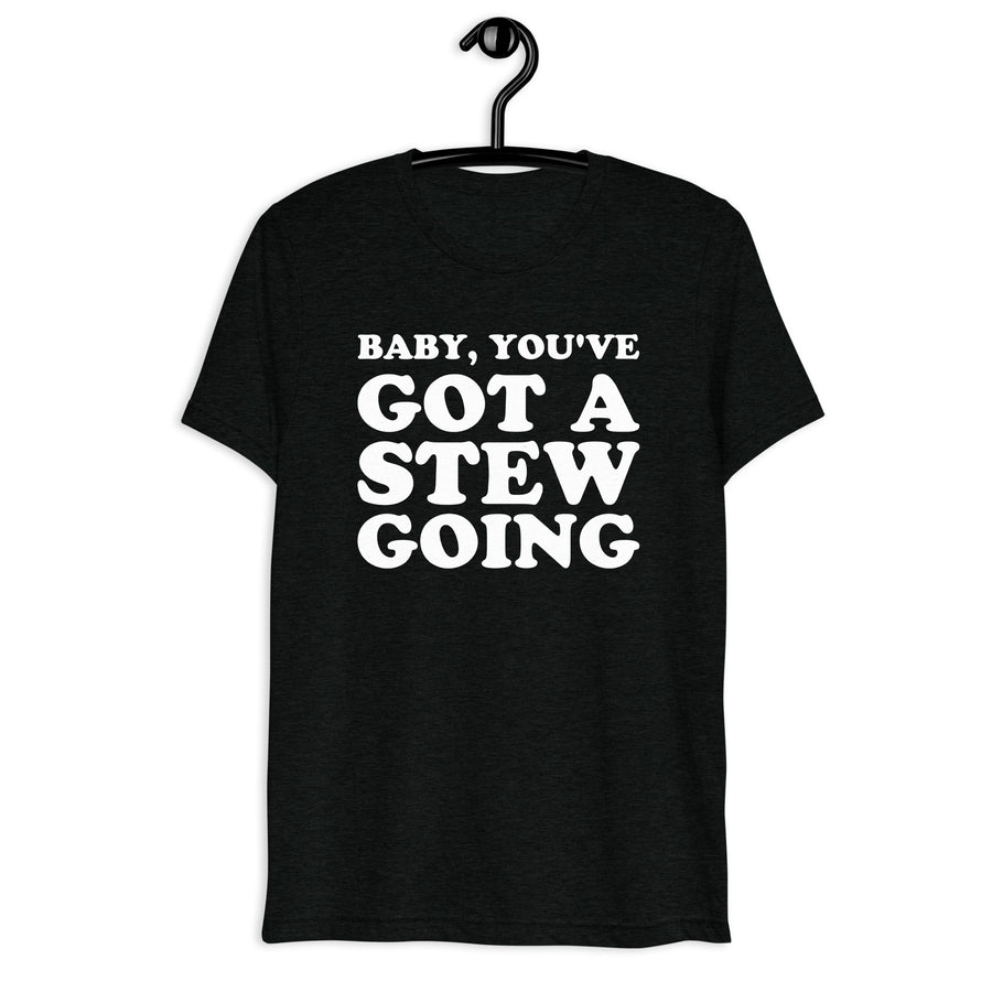 Front hanger mockup of the black tri-blend Baby, You've Got a Stew Going quote T-shirt