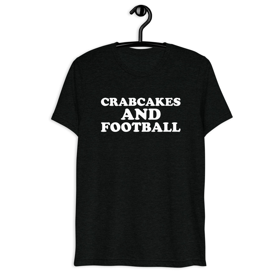 Front hanger view of black tri-blend quote shirt reading Crabcakes and Football