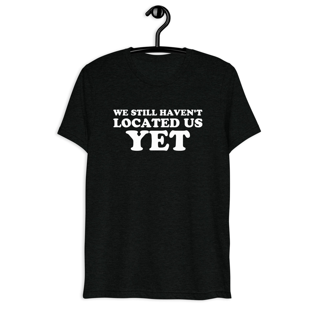 Front hanger view of black tri-blend quote shirt reading We Still Haven't Located Us Yet