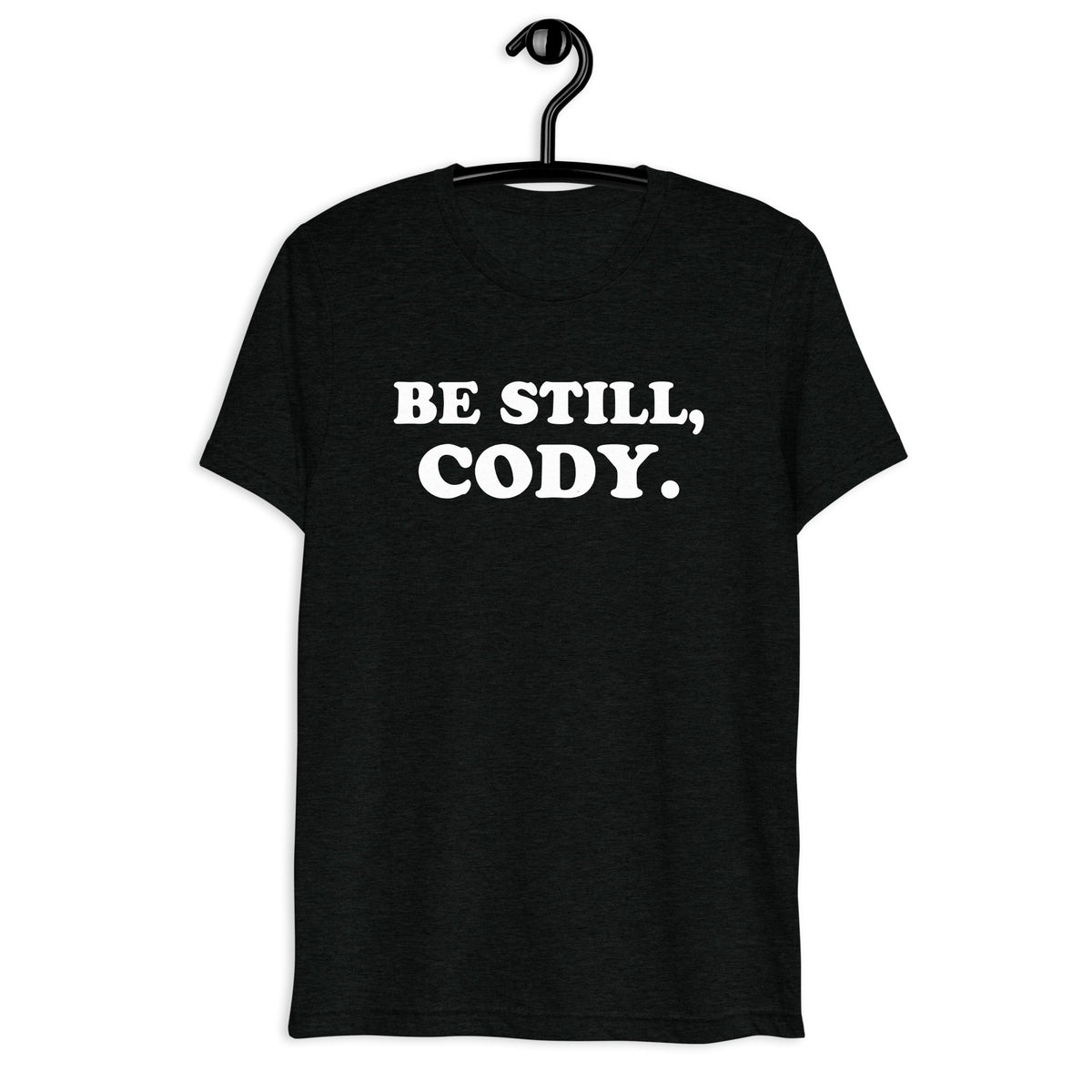 Front hanger view of black tri-blend quote shirt reading Be Still, Cody.