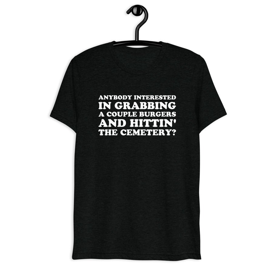 Front hanger view of black tri-blend quote shirt reading Anybody Interested in Grabbing a Couple Burgers and Hittin' the Cemetery?