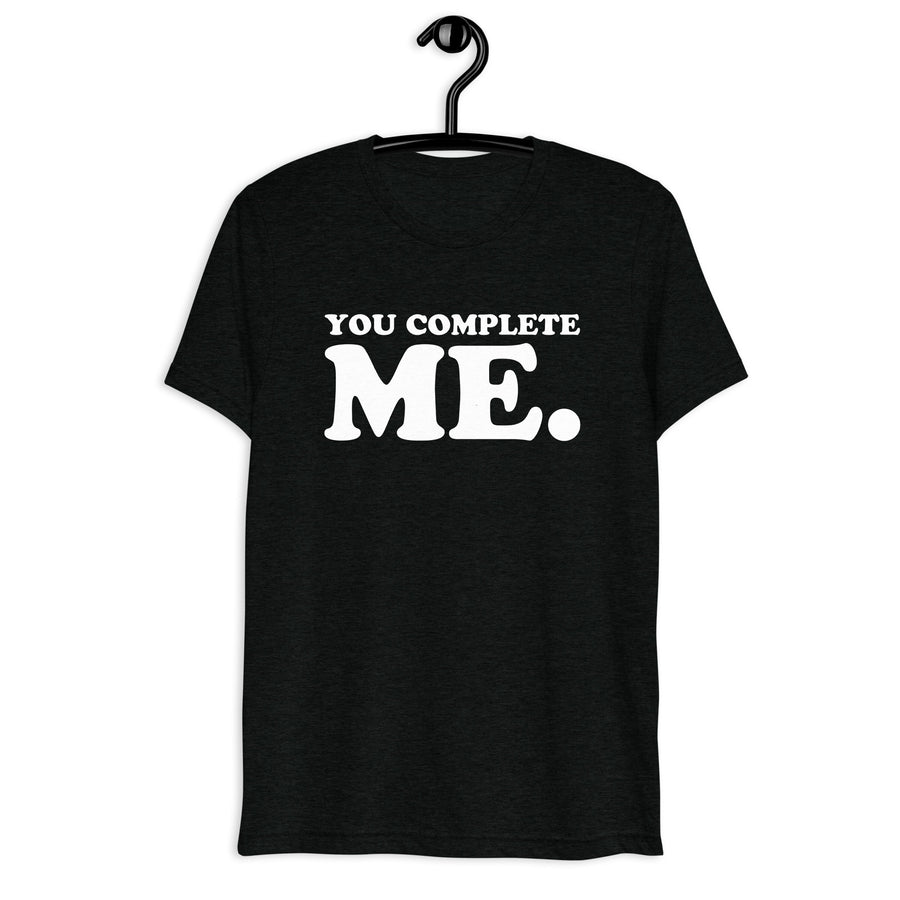 Front hanger view of black tri-blend quote shirt reading You Complete Me.