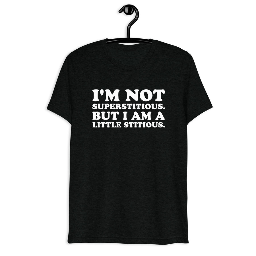 Front hanger view of black tri-blend quote shirt reading I'm Not Superstitious. But I Am a Little Stitious.