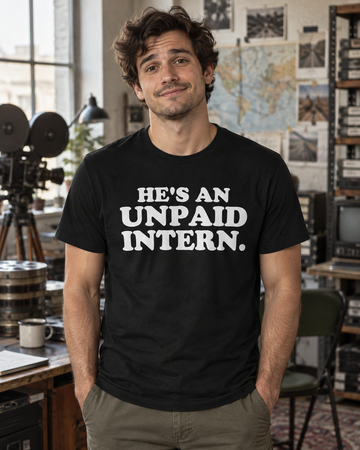 AI-generated lifestyle visualization: person wearing the black tri-blend He's an Unpaid Intern. quote T-shirt in a quirky documentary production office with analog equipment, maps, and symmetrical shelving